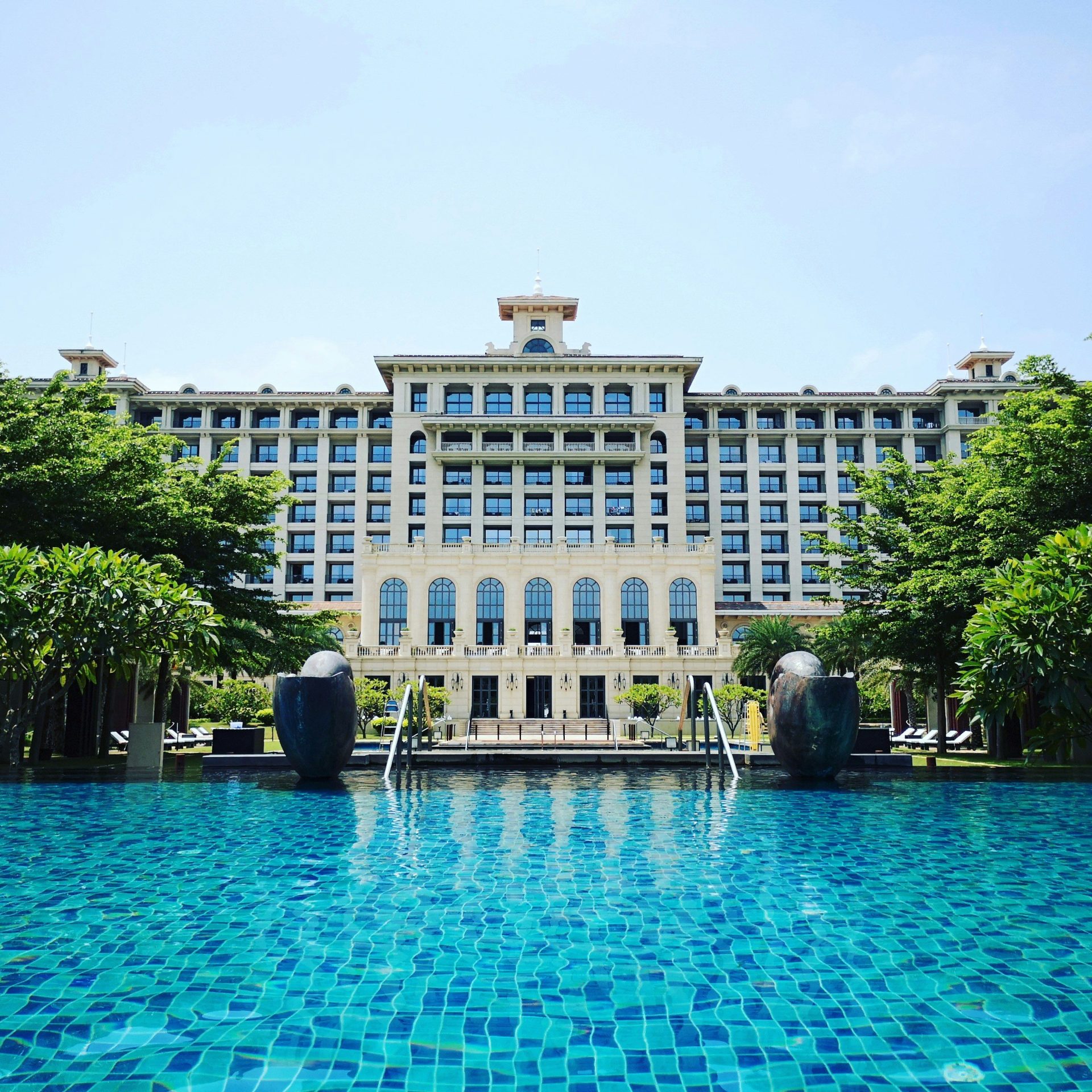 blue swimming pool beside white building