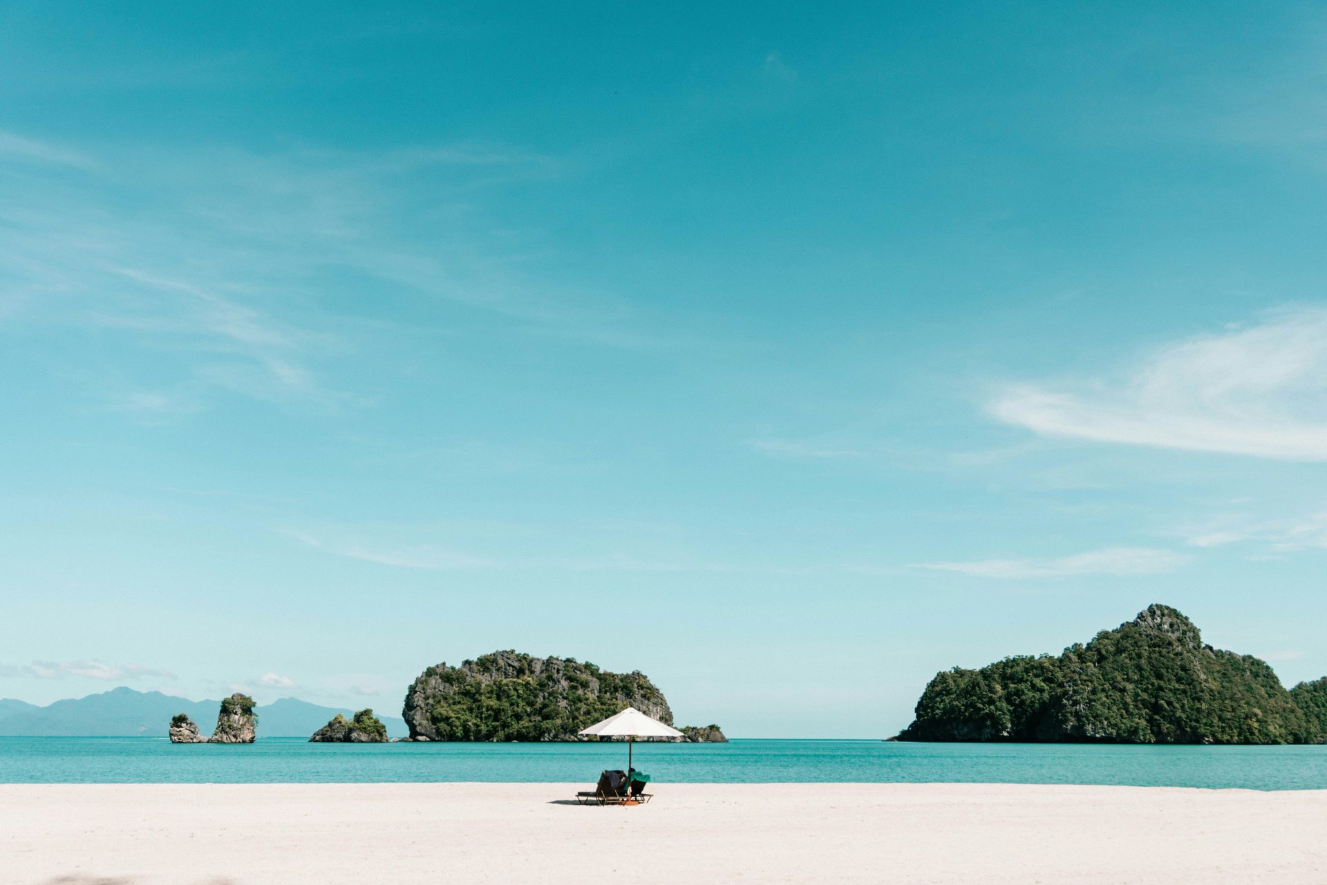 A sandy beach with a boat in the water